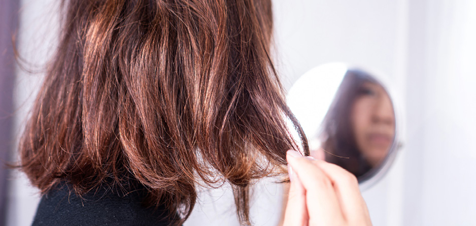 A young woman assessing her dyed hair