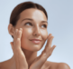 A woman with her hands on her face, applying face cream thinking about urea in moisturisers vs. other ingredients